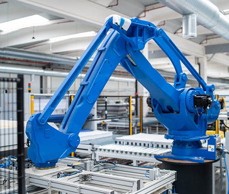 A blue colored robotic arm working in an industrial factory for automated production